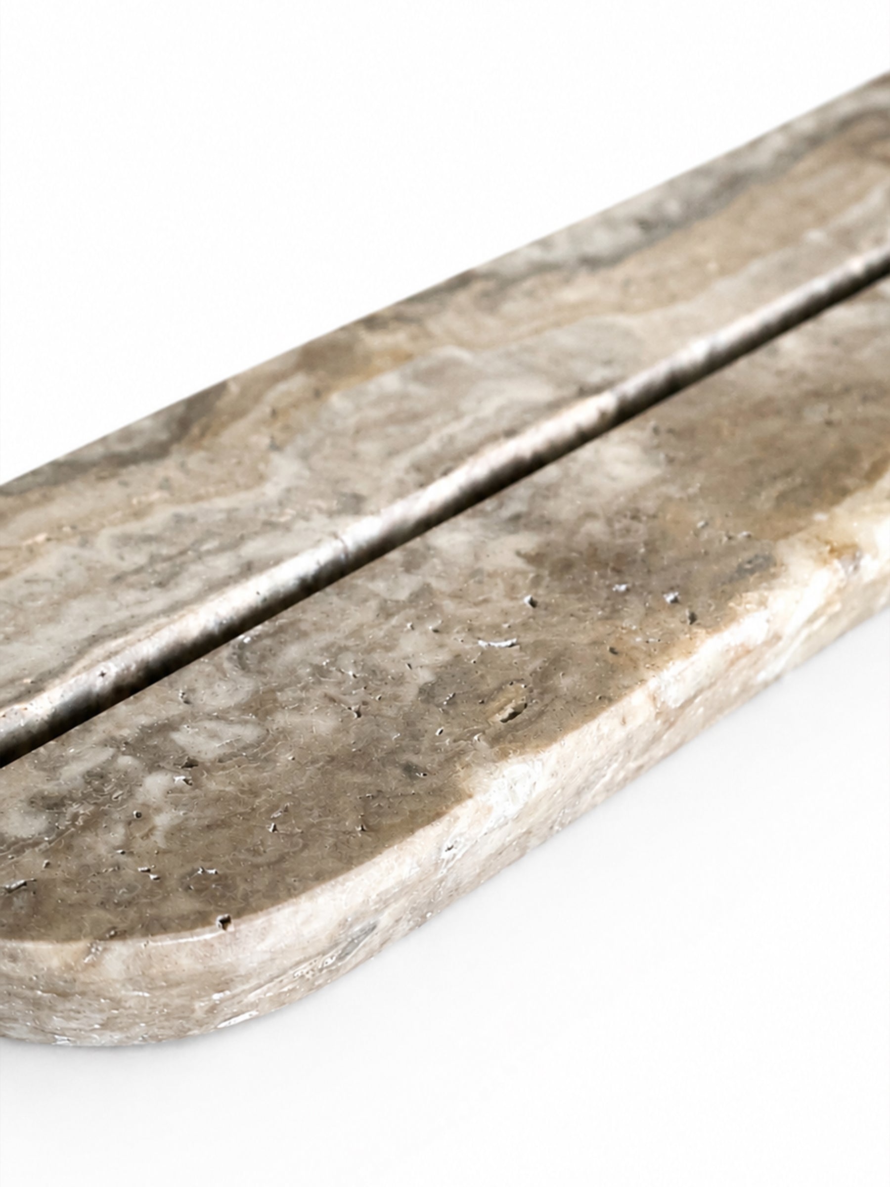 A close-up of a polished stone tray or decorative board with a natural marbled texture in gray, beige, and brown tones, set against a plain white background.
