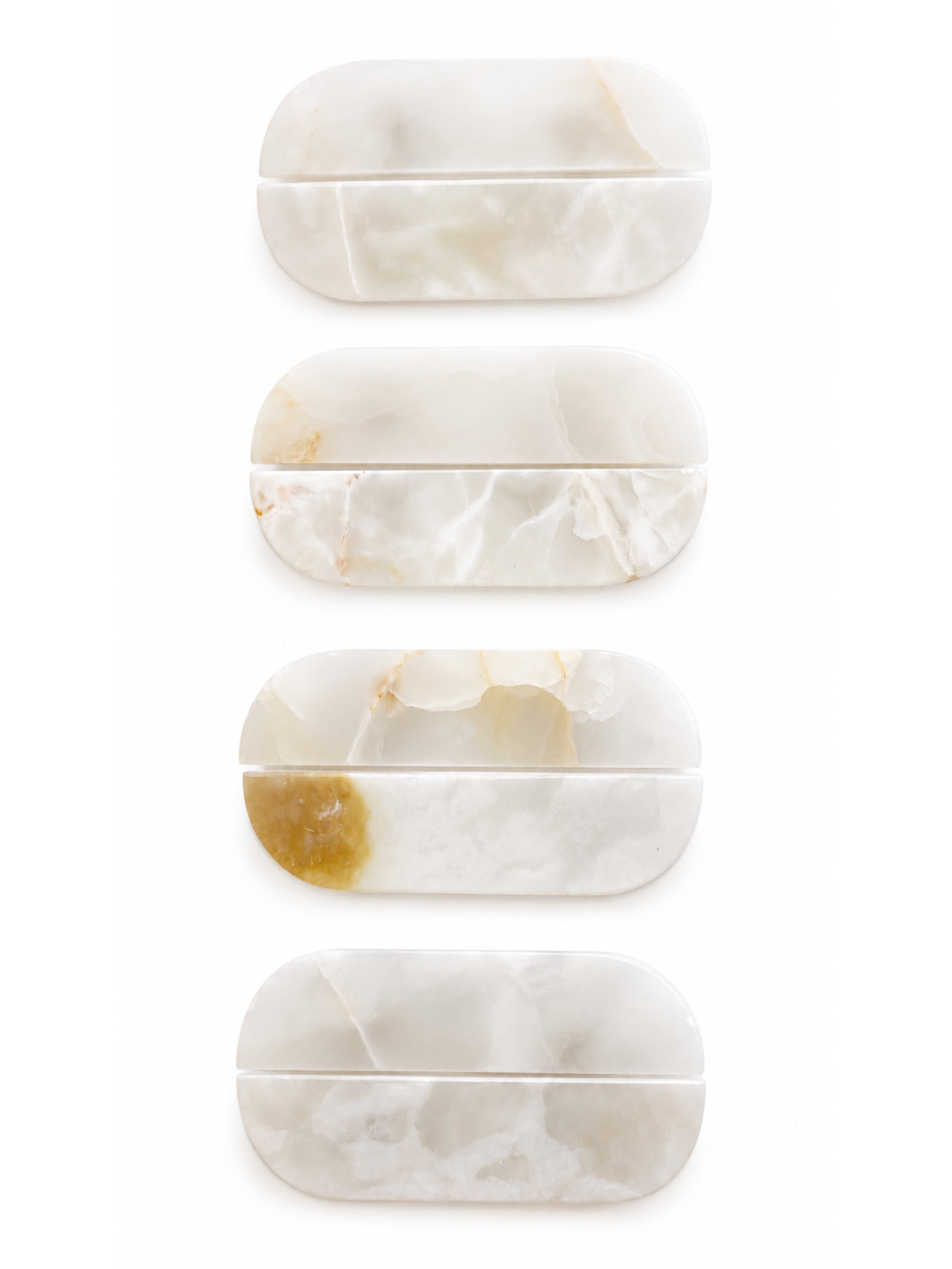 Four oval-shaped hard cases made of natural white and cream marbled stone, arranged vertically on a plain white background.