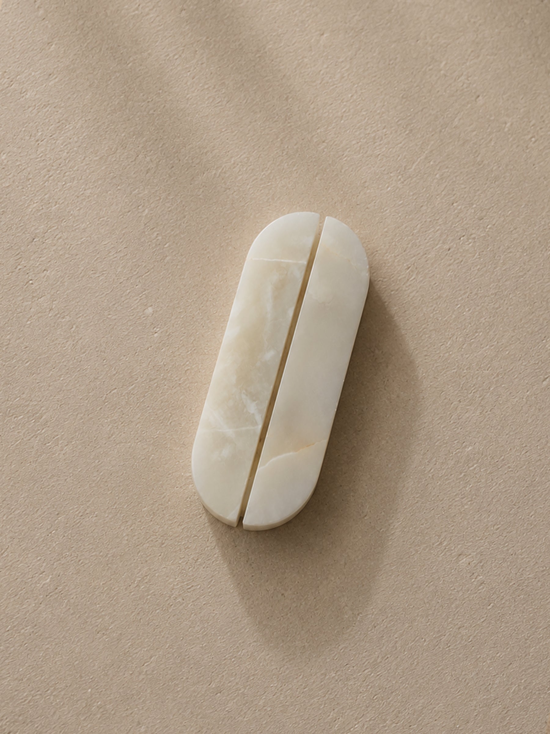 White Onyx cabinet handles by Formed Home handcrafted from genuine natural stone, displayed as a matching pair on a textured neutral background.