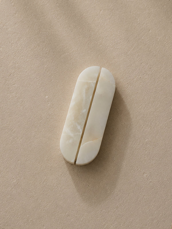 White Onyx cabinet handles by Formed Home handcrafted from genuine natural stone, displayed as a matching pair on a textured neutral background.